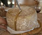 Cutting a sheep cheese with a knife. Sheep cheese is one of the most appreciated thanks to its intensity, aroma and flavor