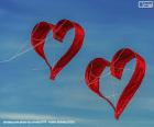 Two kites of hearts flying in a blue sky, to celebrate Valentine's Day