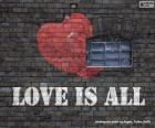 Brick wall with graffiti painted with the phrase, love is all