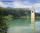Lake Reschen and its submerged bell tower. It is an artificial lake created by joining two natural lakes, Lake Reschensee and Lake Mittersee, in Italy.