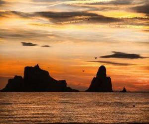 Sunset over the sea with the Medes Islands in the background puzzle