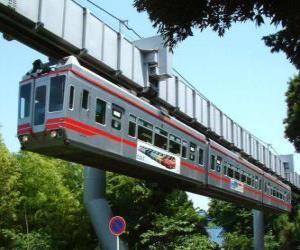 Suspended monorail. Passengers of the monorail enjoying the views of the fairground puzzle