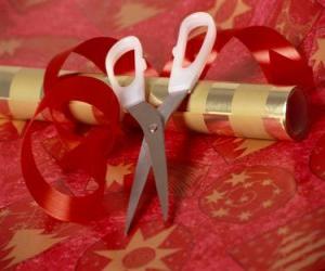 Tools to wrap holiday gifts: scissors, paper and ribbon for the tie puzzle